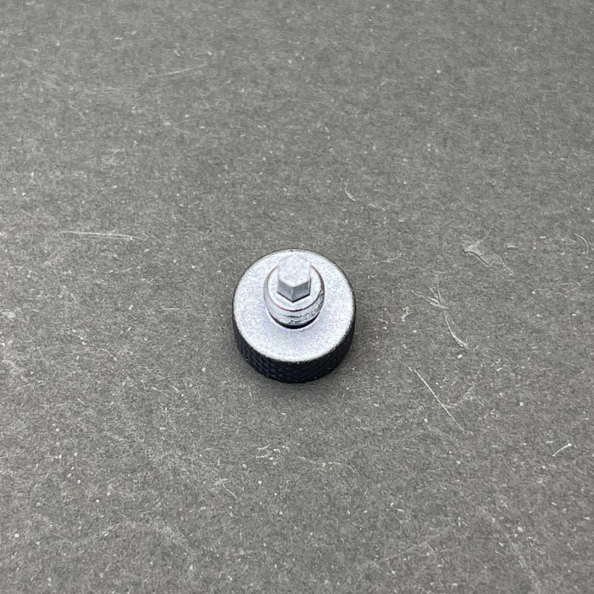 An angled view of the UV Scope Rod Wrench Tool on a gray surface, showing the top of the hexagonal shaft and the textured, knurled head.