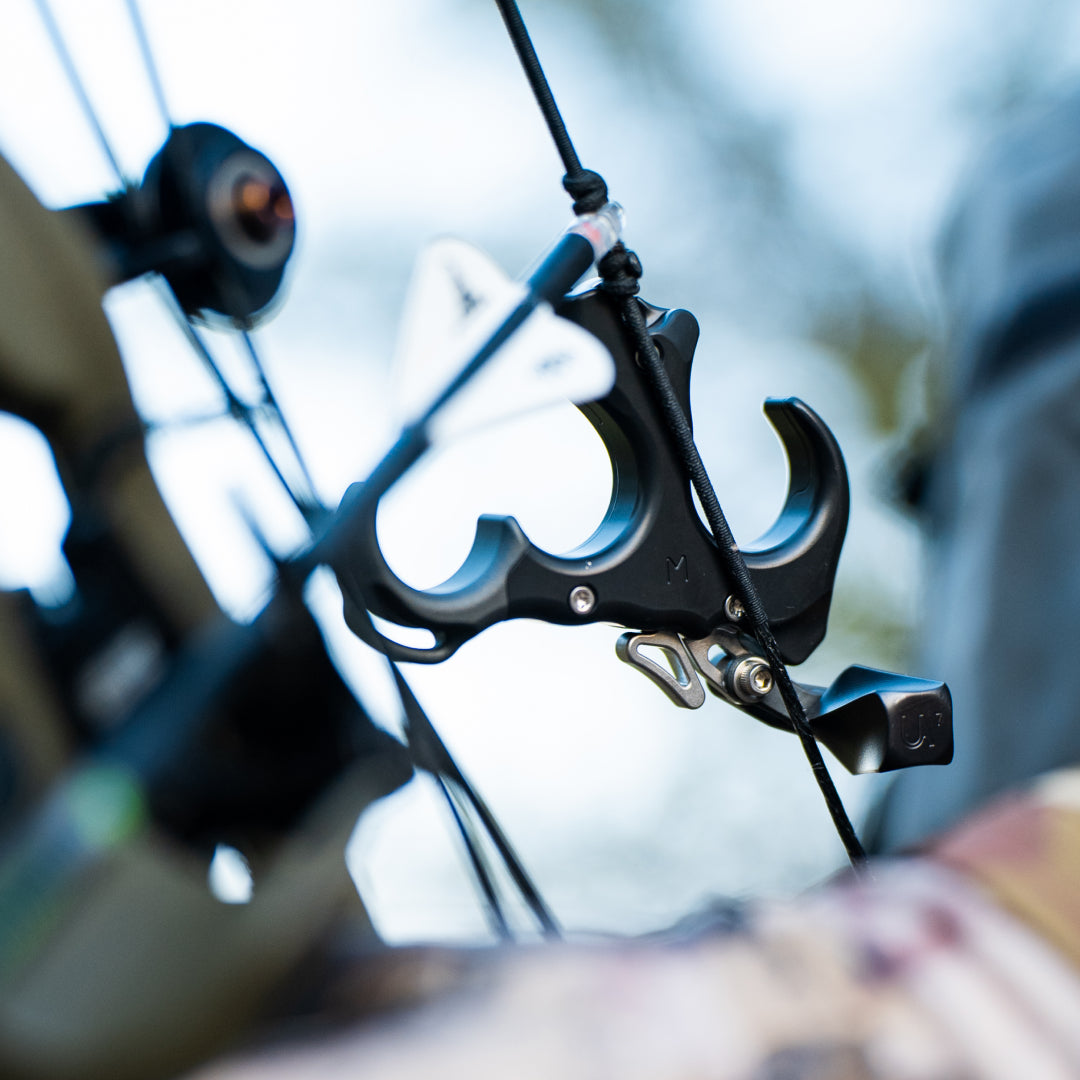 Black UV BUTTON™ on bow string with black Helix thumb knob
